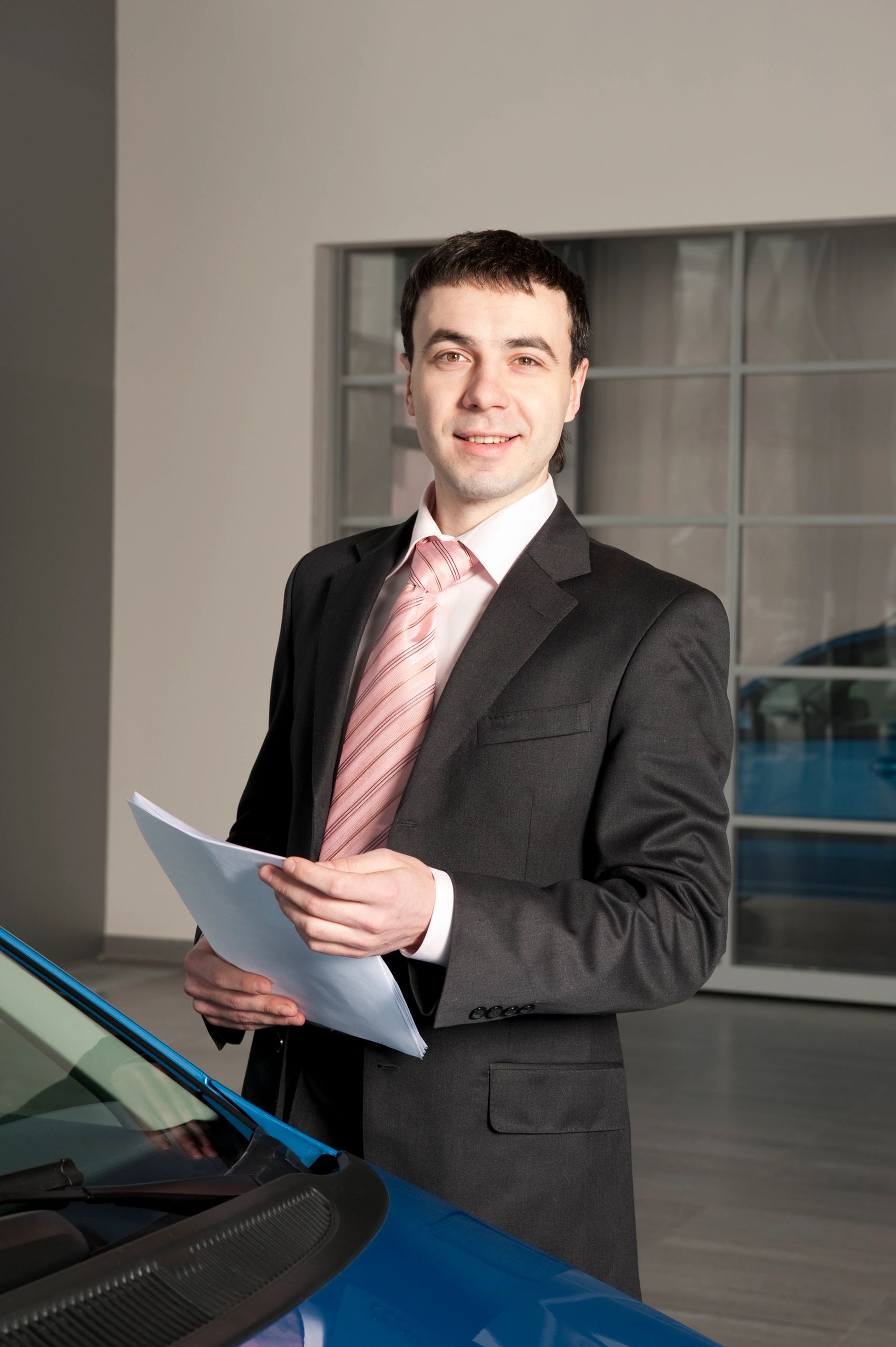 Automotive dealership consultant beside a vehicle
