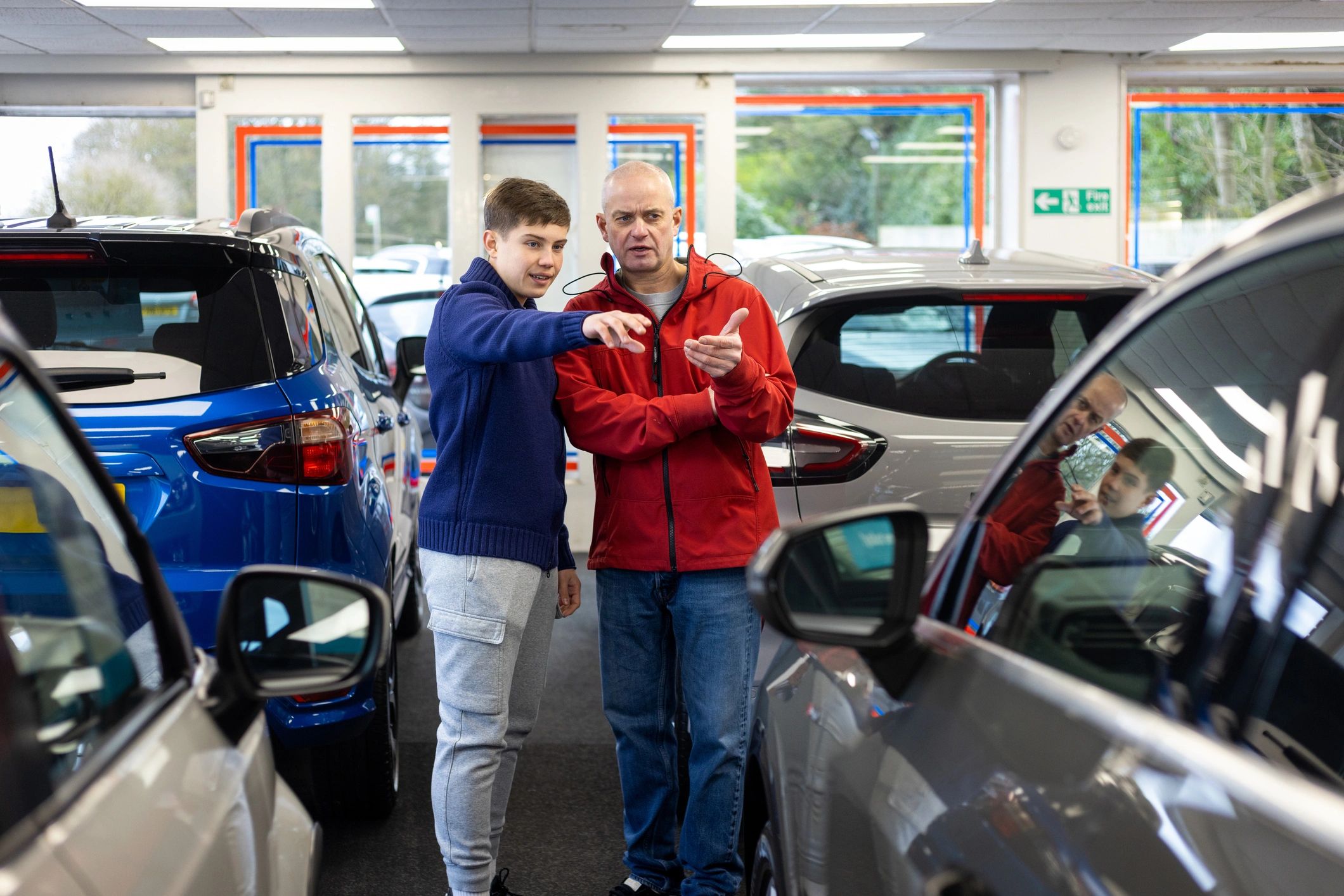 Customers browsing vehicles in a dealership showroom