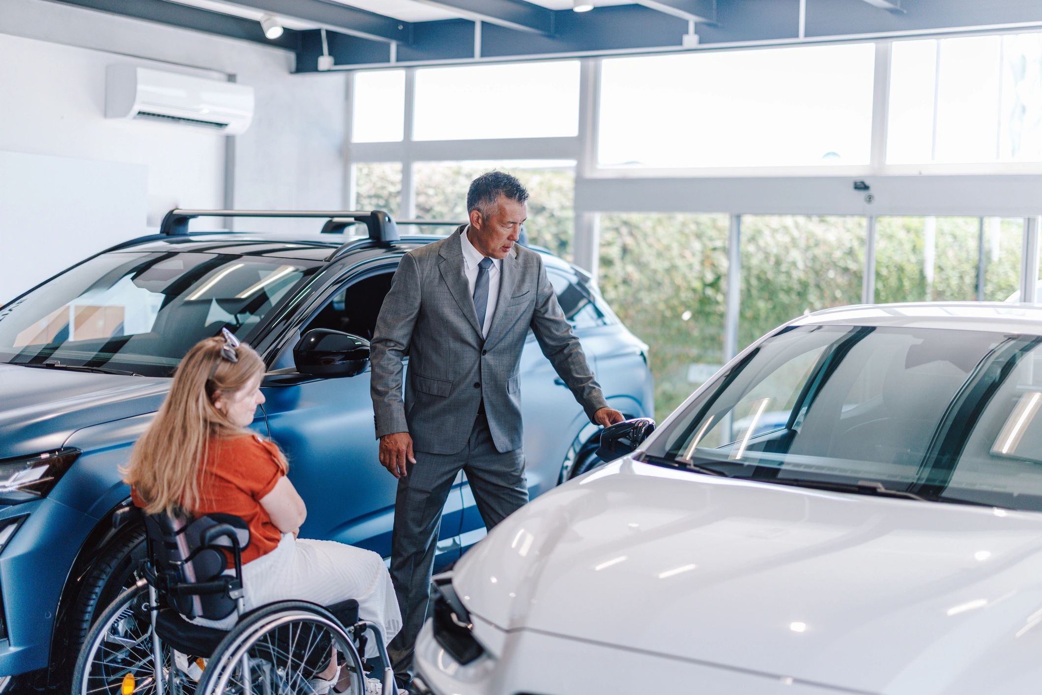 Jac Motor team member assisting a customer in a dealership showroom